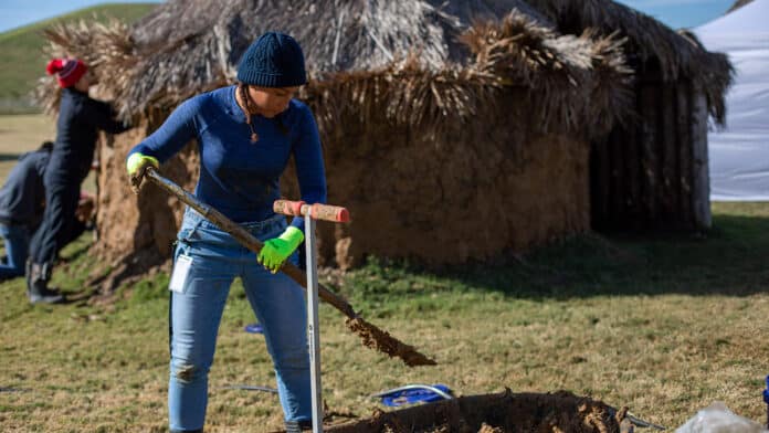 Aliiah Myers works on traditional Choctaw winter home