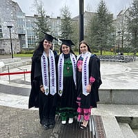 Three women stand in their Choctaw graduation stoles in Cork, Ireland.