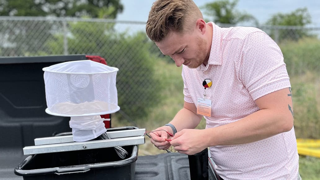 Mason Emmert sets up a mosquito trap