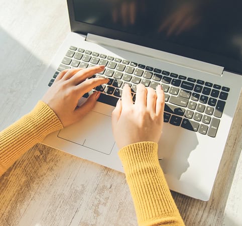 Woman typing on a laptop keyboard